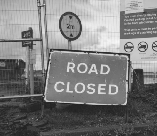 grayscale photo of road closed